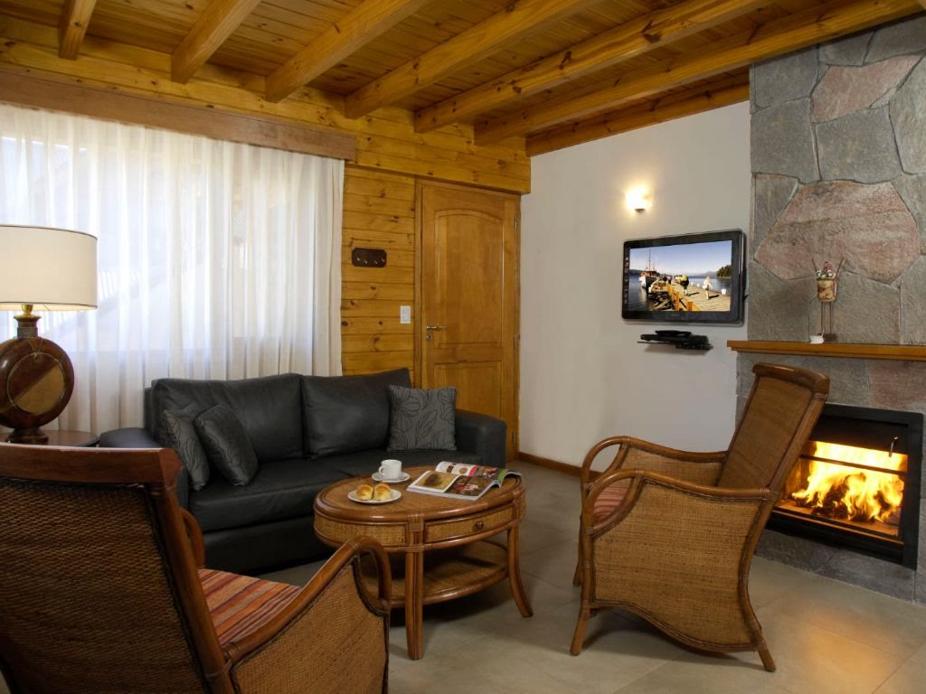 Living con sillones de cuero y hogar a leña encendido